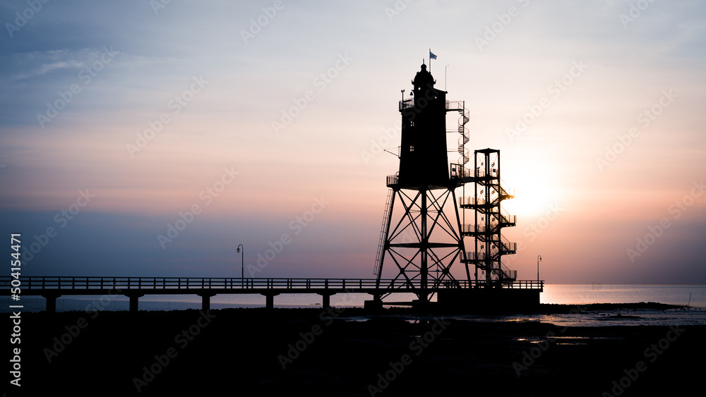 Leuchtturm mit Steg bei Sonnenuntergang