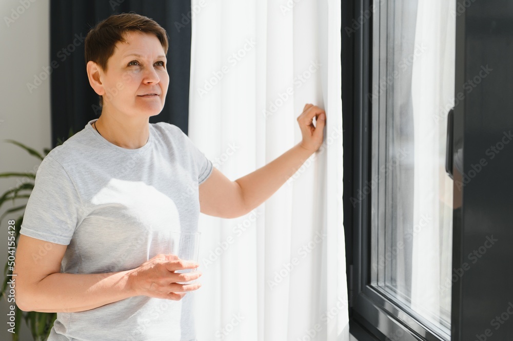 Mature Woman Drink. Middle Age Female In Casual Clothes Has Fresh Water With Lemon Juice On Couch At Home. Concept of Healthy Diet Mature Woman Drink. Middle Age Female In Casual Clothes Has Fresh Water With Lemon Juice On Couch At Home. Concept of Healthy Diet