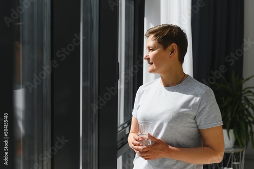 Free Download Mature Woman Drink. Middle Age Female In Casual Clothes Has Fresh Water With Lemon Juice On Couch At Home. Concept of Healthy Diet - GFXLoad