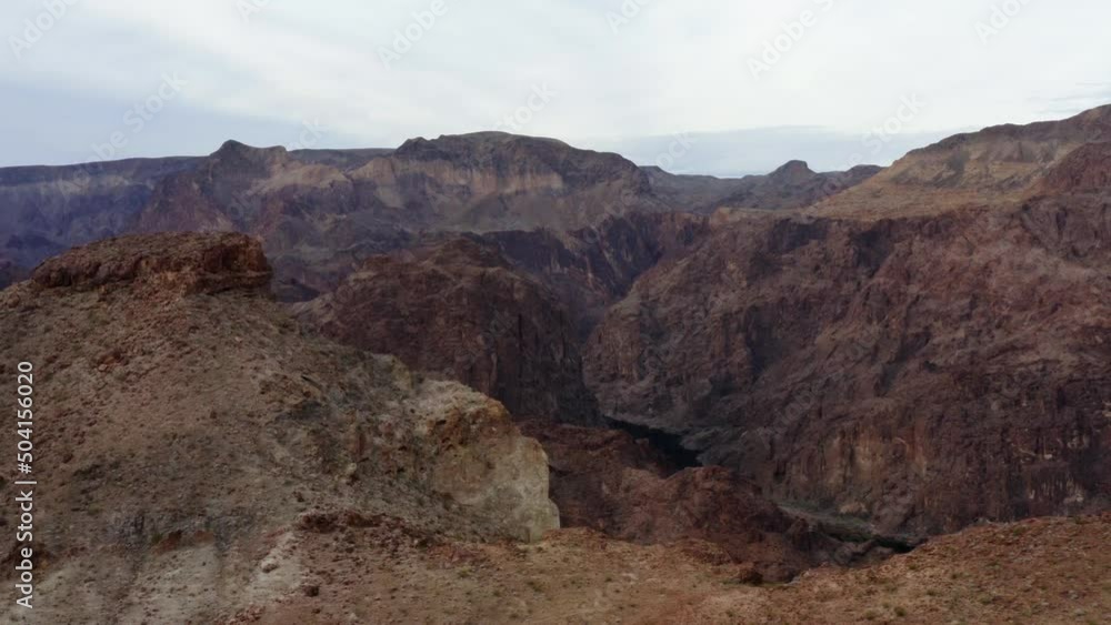 Aerial drone view over mountains revealing the Colorado river in middle of steep cliffs, in Kingman, USA Aerial drone view over mountains revealing the Colorado river in middle of steep cliffs, in Kingman, USA