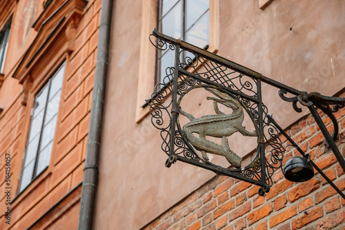 Warsaw, Poland, 13 October 2021: picturesque street with colorful buildings in historic center in medieval city, renaissance and baroque historical buildings, ancient signboard with a crocodile