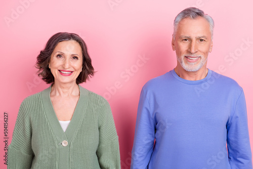 Portrait of two handsome beautiful cheerful people team isolated over pink pastel color background