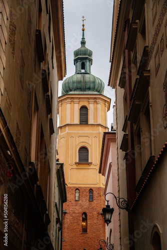 Warsaw, Poland, 13 October 2021: picturesque street with colorful buildings in historic center in medieval city, renaissance and baroque historical buildings at old town, St. Martin's Church tower photo