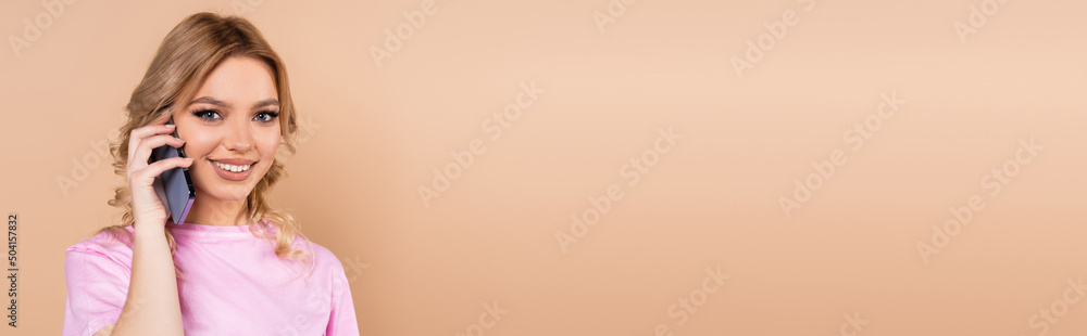 happy young woman talking on mobile phone isolated on beige, banner. happy young woman talking on mobile phone isolated on beige, banner.