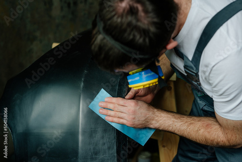 Close up of worker sanding with sandpaper