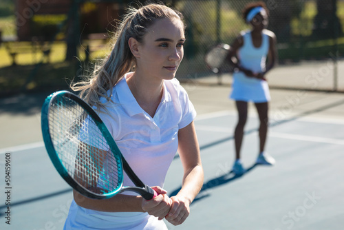 Beautiful young female caucasian female player with african american partner at tennis court © WavebreakMediaMicro