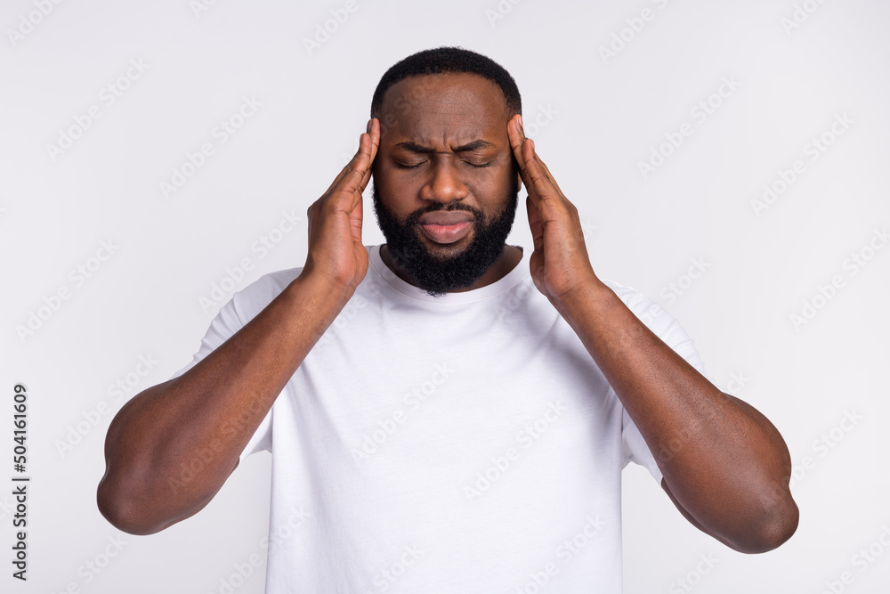 Photo of unhappy tired guy dressed casual t-shirt arms temples having pain isolated white color background Photo of unhappy tired guy dressed casual t-shirt arms temples having pain isolated white color background