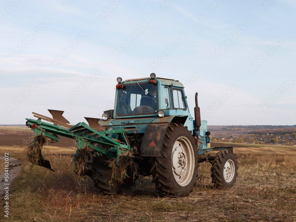 Old tractor with a plow on the field. Old tractor with a plow on the field.