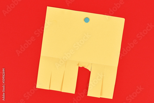 Slika na platnu Empty yellow tear-off stub paper note without text on red background