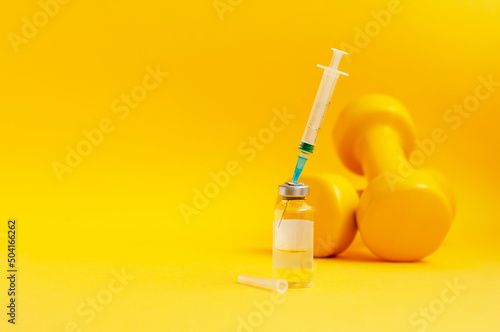 syringe is stuck in jar, there are dumbbells on yellow background next to it, a horizontal photo, copy space. concept of doping in sports, steroids, testosterone and other drugs prohibited in sports. photo