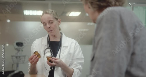 Female Doctor giving SeniorPatient  Pills in Doctors Office photo