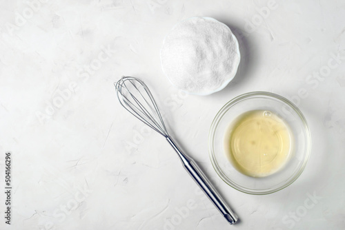 Cuadro en lienzo ingredients for the French meringue dessert are egg white, sugar and a whisk on a gray surface, copy space