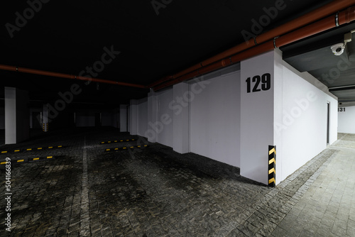 large underground parking with white walls and cobblestones