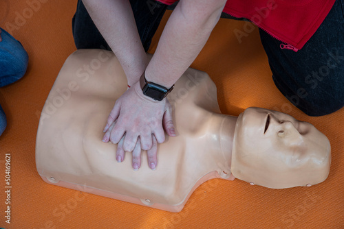 Woman doing CPR on a mannequin for training. Direct heart massage. First aid training on medical dummy. heart massage in cardiac arrest photo