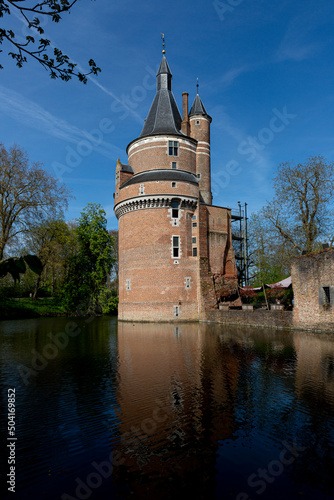 Rounded brick fortified tower and remains of picturesque Duurstede castle with access bridge over the moat surrounding the fortress reflecting in the water in the foreground