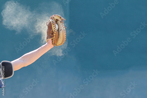 Baseball catcher catching ball in dust mitt, baseball in mitt 
