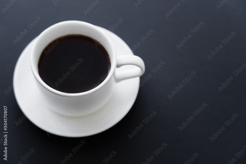 top view of aromatic cup of coffee with saucer on black. top view of aromatic cup of coffee with saucer on black.