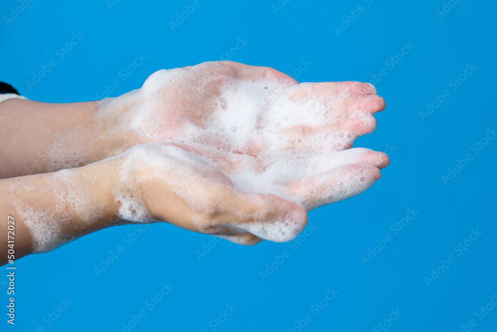 Woman washing hands on blue background