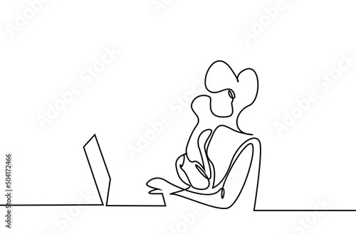 a woman working from home does work at a laptop and computer with her baby in her arms