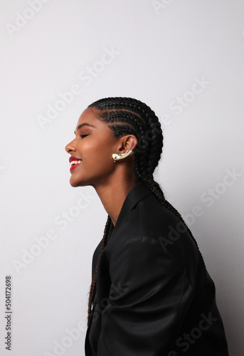 Foto Vertical portrait of African American woman with long braids posing indoor