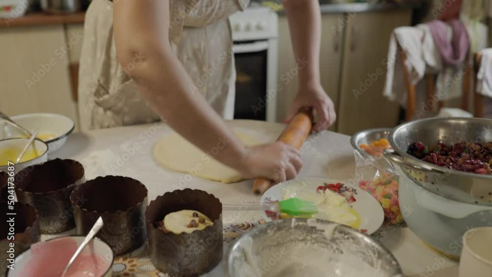 Woman rolls out raw dough with a rolling pin in slowmo. Preparing dough for baking. Making a thin baking dish. Stages of baking and confectionery preparation. Woman rolls out raw dough with a rolling pin in slowmo. Preparing dough for baking. Making a thin baking dish. Stages of baking and confectionery preparation.