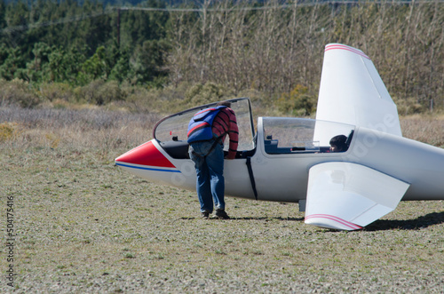 person boarding a glider with a parachute on his back photo