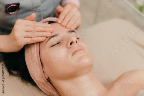 Girl enjoying a relaxing facial massage at a cosmetology spa.