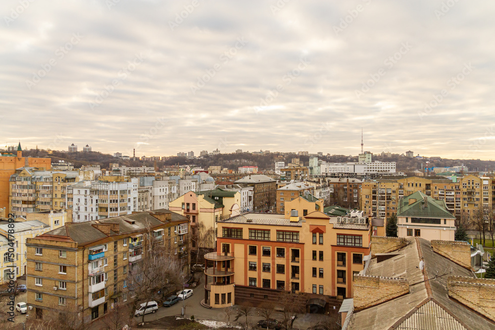 Kyiv, Ukraine – February 06, 2016: A beautiful panorama of Podil region during sunset. Aerial view on residential and industrial areas. Different architectural style. Historical area, Dnipro river.