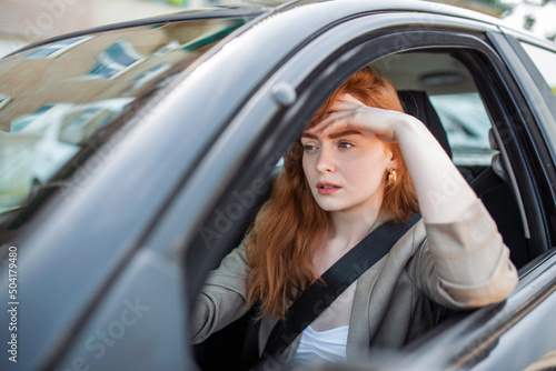 Nervous female driver sits at wheel, has worried expression as afraids to drive car by herself for first time. Frightened woman has car accident on road. People, driving, problems with transport © Graphicroyalty
