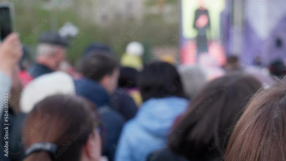 A crowd of people at a street music concert defocusing, selective focus A crowd of people at a street music concert defocusing, selective focus