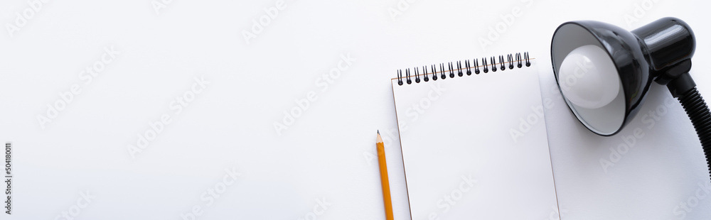 top view of blank notebook near pencil and lamp on white, banner. - obrazy, fototapety, plakaty 