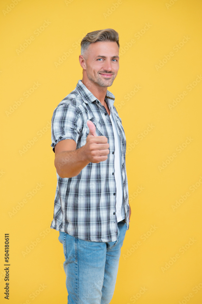 smiling mature man with grizzle hair on yellow background. thumb up smiling mature man with grizzle hair on yellow background. thumb up