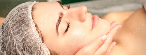 Facial massage. Hands of a masseur massaging neck of a young caucasian woman in a spa salon, the concept of health massage