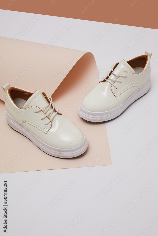 Trendy leather female sneakers. White milky color,