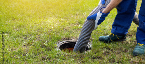 man pumping out house septic tank. drain and sewage cleaning service. copy space photo