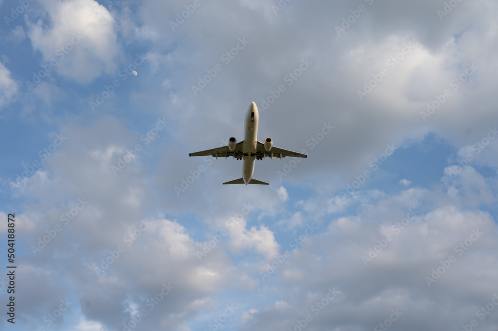 Beautiful panoramic background with flying plane in blue sky. The passenger plane with the landing gear taken off will take off in the sky. Travel concept. Wide angle stationery or web banner Beautiful panoramic background with flying plane in blue sky. The passenger plane with the landing gear taken off will take off in the sky. Travel concept. Wide angle stationery or web banner