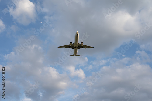 Beautiful panoramic background with flying plane in blue sky. The passenger plane with the landing gear taken off will take off in the sky. Travel concept. Wide angle stationery or web banner 