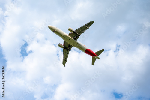 Beautiful panoramic background with flying plane in blue sky. The passenger plane with the landing gear taken off will take off in the sky. Travel concept. Wide angle stationery or web banner © lancho