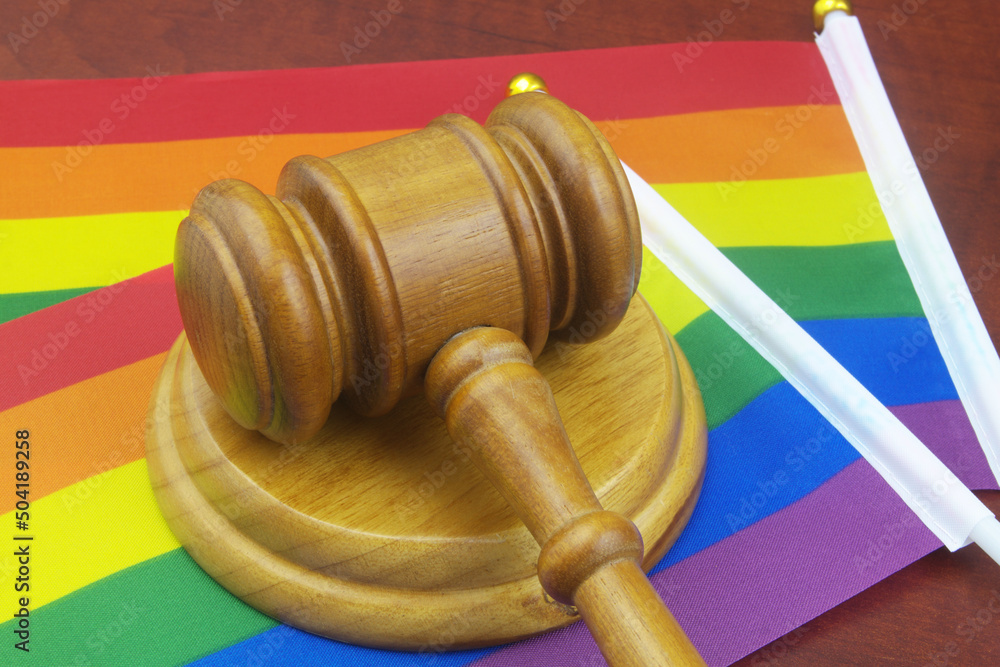 LGBT rights, equality and laws concept. Wooden judge gavel with LGBT flags.	