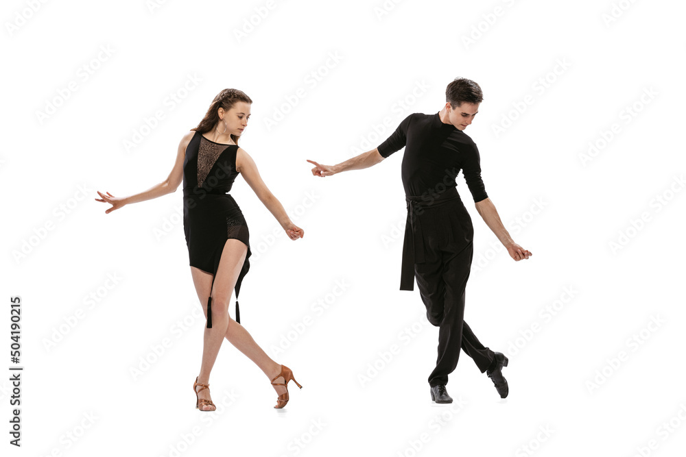 Quickstep. Dynamic portrait of young emotive dancers in black outfits dancing ballroom dance isolated on white background. Concept of art, beauty, music, style. Quickstep. Dynamic portrait of young emotive dancers in black outfits dancing ballroom dance isolated on white background. Concept of art, beauty, music, style.