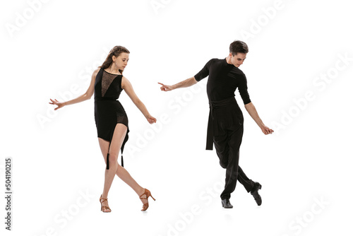 Quickstep. Dynamic portrait of young emotive dancers in black outfits dancing ballroom dance isolated on white background. Concept of art, beauty, music, style.