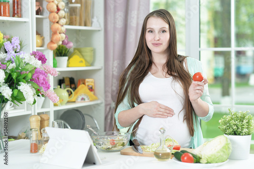 beautiful pregnant  young woman cooking  in kitchen