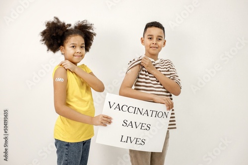 Картината върху платно Two multiracial kids holding a poster that vaccination saved lives