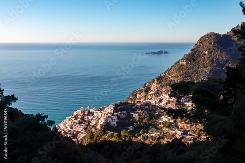 Panoramic view on colorful houses of coastal town Positano, Amalfi Coast, Italy, Campania, Europe. Branch of tree in foreground. Vacation at coastline at Tyrrhenian, Mediterranean Sea. Path of Gods