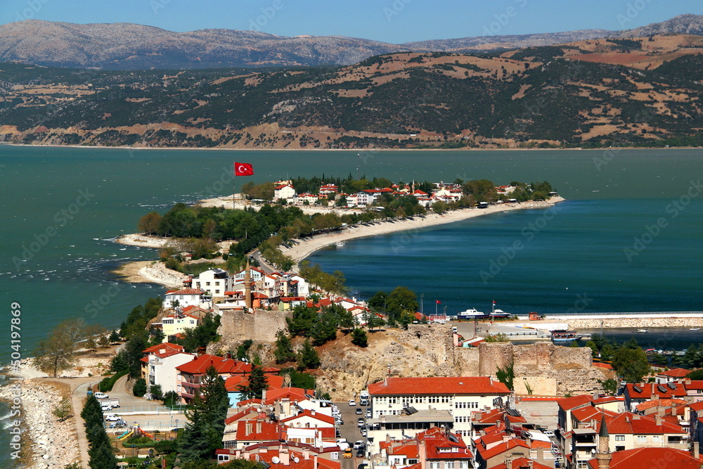 View of the historic part of Eğirdir with its castle in the middle of the lake of the same name and the mountains in the background in the Isparta region of southern Turkey