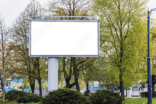 Large billboard mockup against the background of trees during the day, general plan
