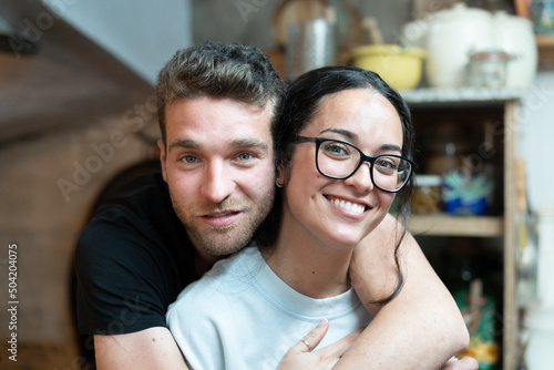 Young teenage couple hugging in the kitchen.