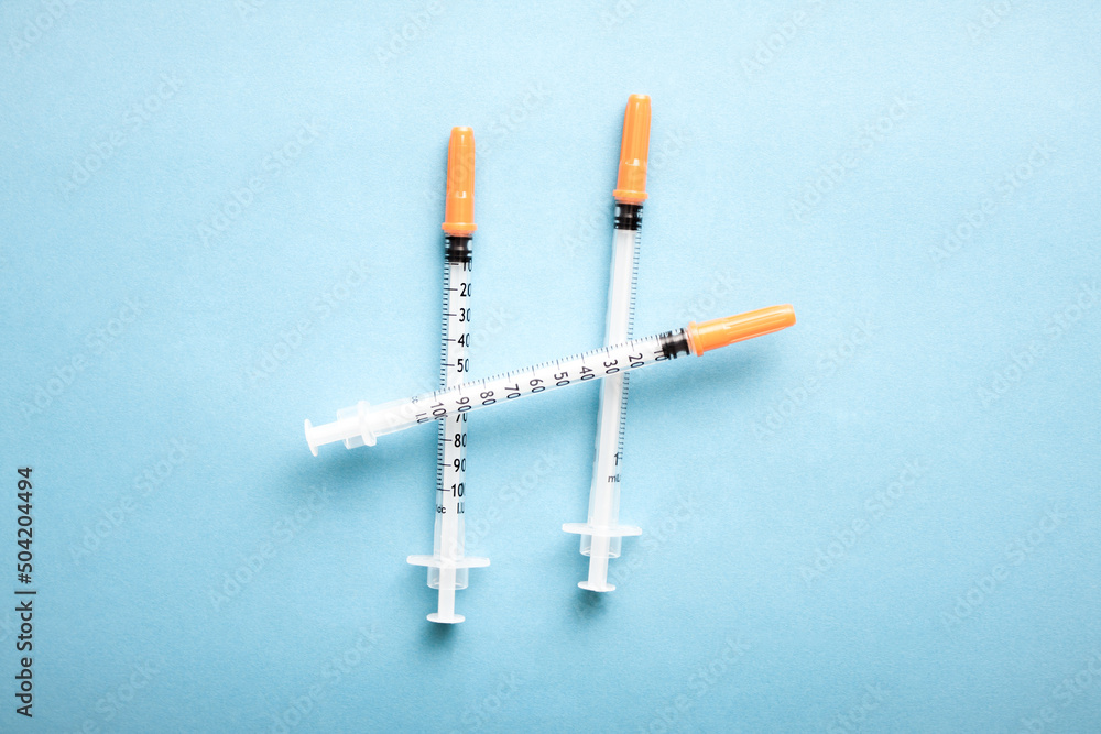 Medical syringes on blue background. Simple medicine concept flat lay. Medical syringes on blue background. Simple medicine concept flat lay.