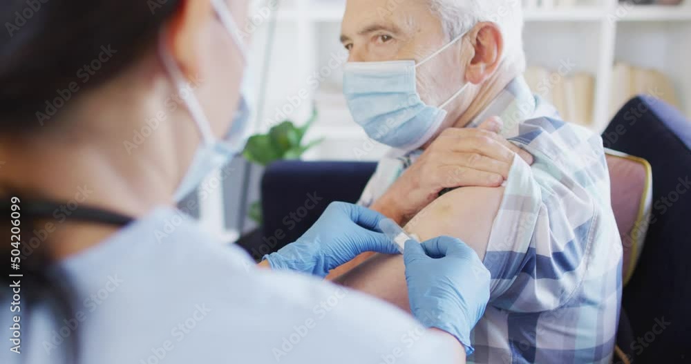 Video of hands of biracial female doctor vaccinating caucasian senior man Video of hands of biracial female doctor vaccinating caucasian senior man