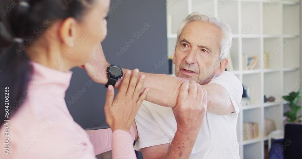 Video of happy biracial female physiotherapist exercising with caucasian senior man Video of happy biracial female physiotherapist exercising with caucasian senior man